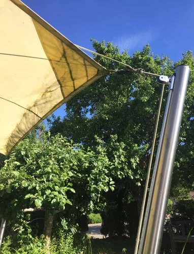 Befestigung eines gelben Sonnensegels an einem Pfosten Befestigung eines gelben Sonnensegels an einem Pfosten